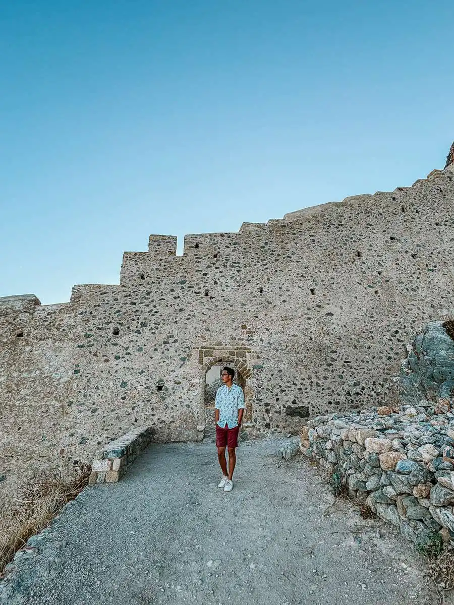 man standing in front of east castle wall in Monemvasia