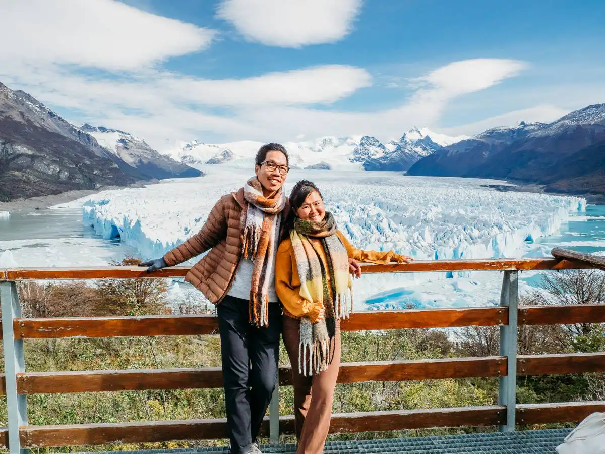 two people standing at the viewpoint of perito moreno glacier