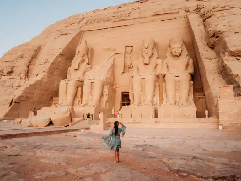 Woman standing in front of statues at abu simbel