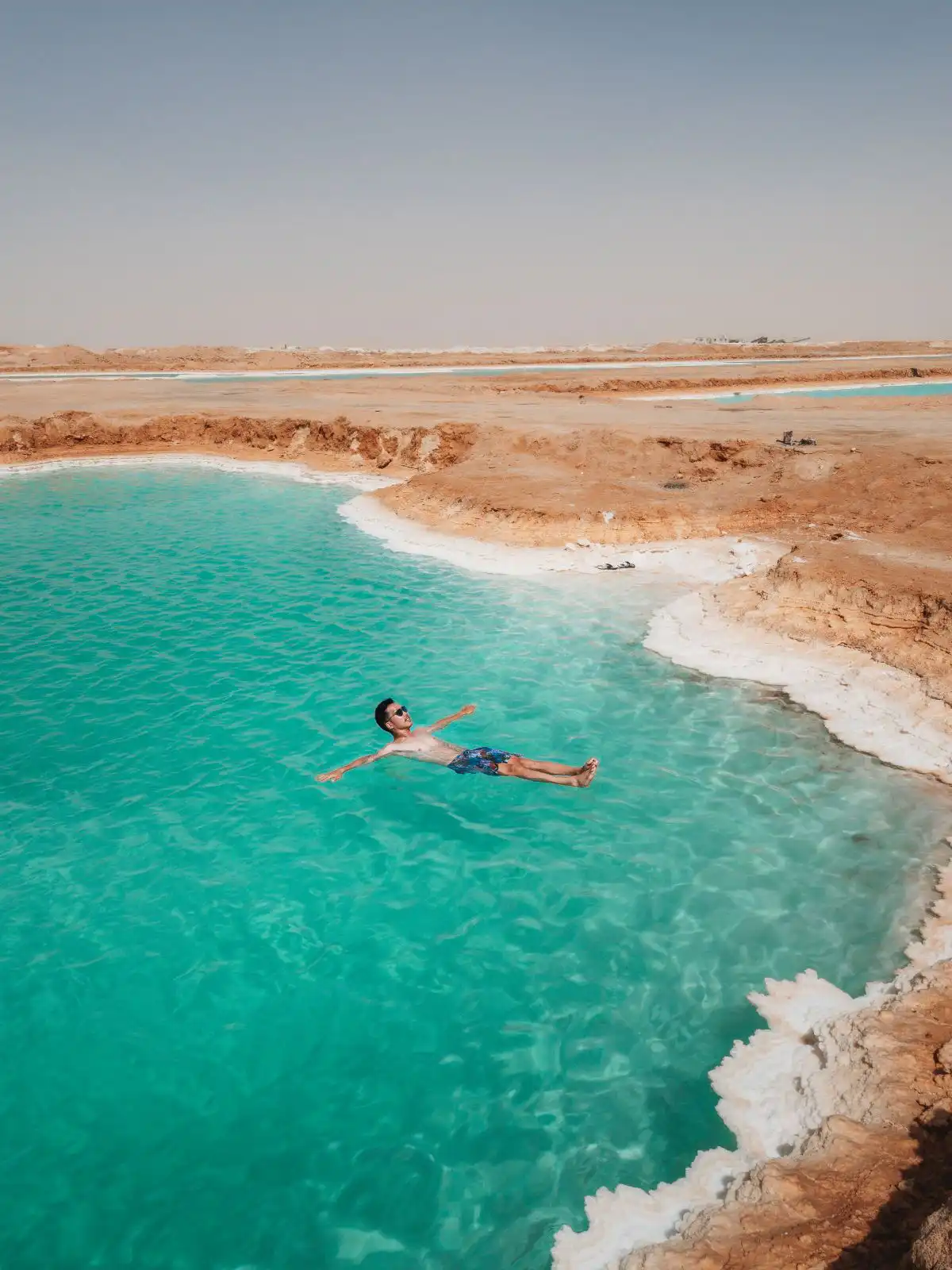 man floating in salt pool in siwa