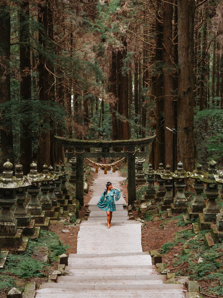 woman standing in forest shrine in Mount Aso