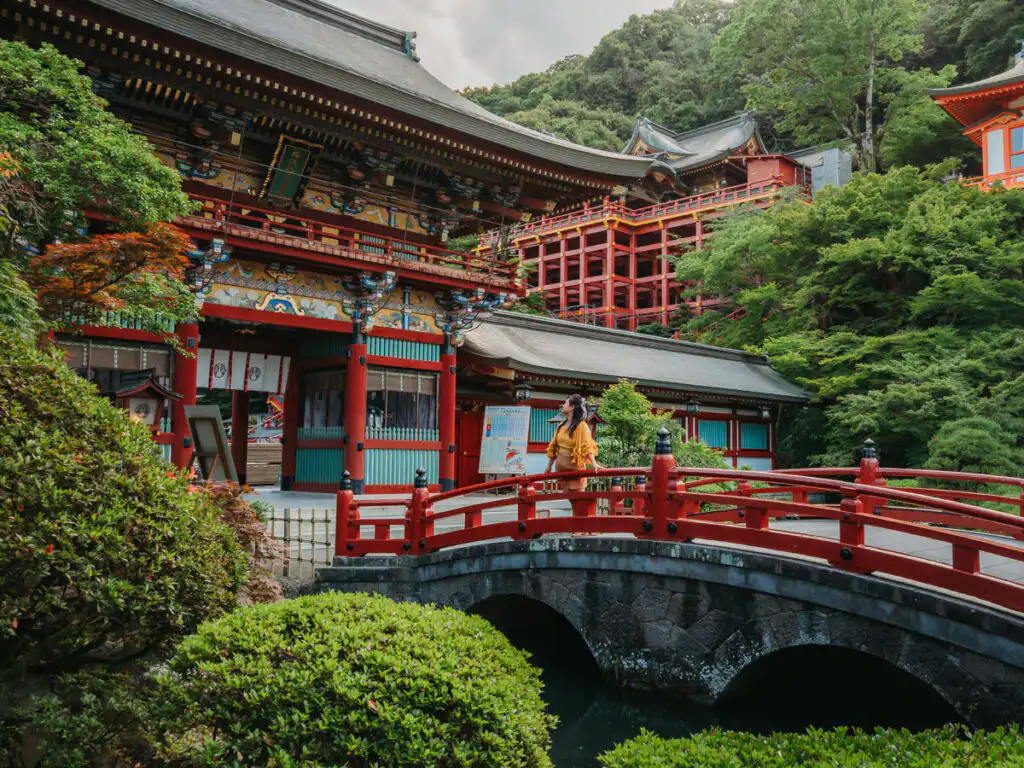 Woman standing on the bridge of yutoku inari shrine