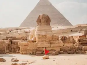 woman standing in front of the Sphynx of the pyramid